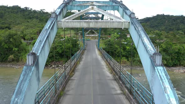 A metal truss bridge, driving over the bridge while the sun comes out alt