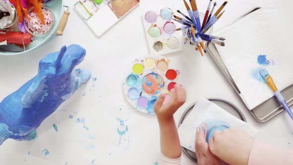 Time lapse. Step by step. Mother and daughter decorating paper mache unicorn together alt