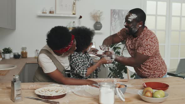 African-American Family Having Fun with Flour while Cooking alt