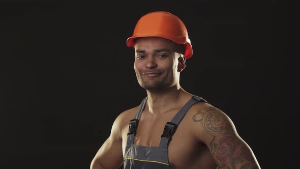 Muscular Ripped Sexy African Male Builder in Workwear and Hardhat Flexing Muscles alt