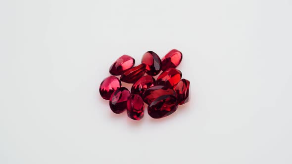 Natural Red Garnet Gemstone on the White Background on the Turning Table alt