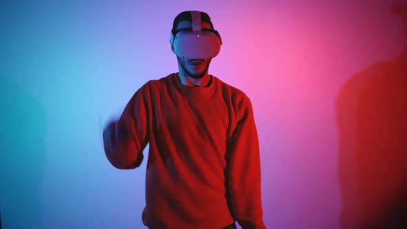 Male Gamer Playing Virtual Reality Game Slashing Left and Right Using VR Controllers in Both Hands alt