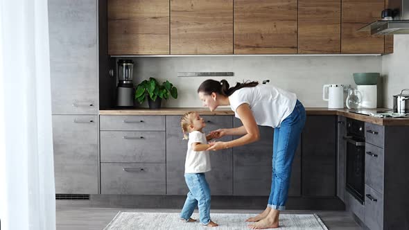 Little Girl and Happy Mother Have a Fun at Home Kitchen alt