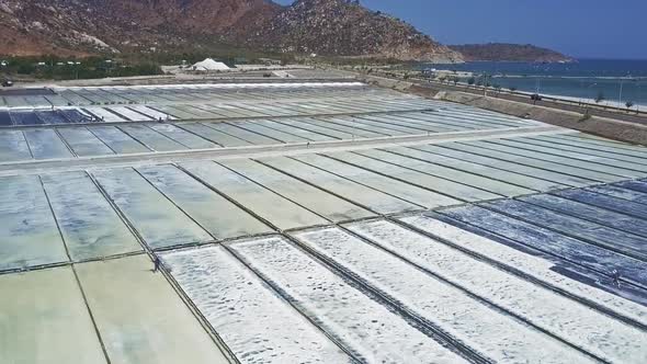 People Collect Salt on Fields Surrounded By Hills alt