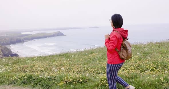 Woman hiking on coastline path in Cornwall