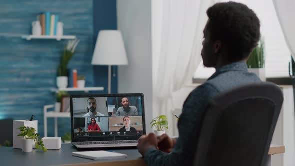 African American Manager on Online Internet Conference Chat with His Coworkers alt