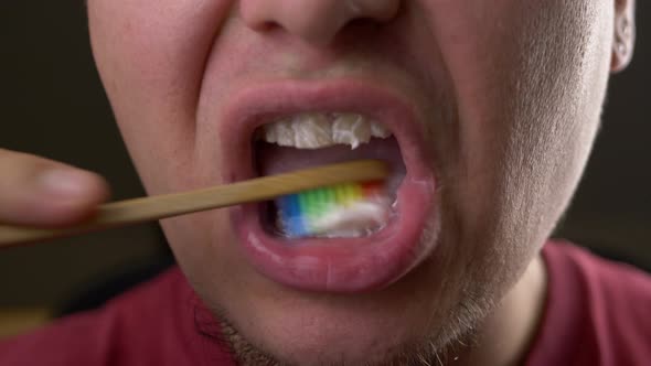Bearded Man Brushing His Teeth with Rainbow Bamboo Toothbrush