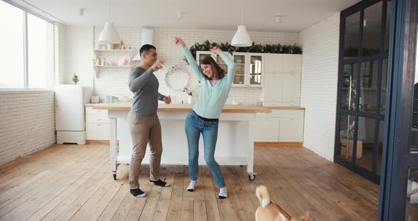 Joyful Man and Woman with Corgi Dog Crazy Fun Dancing at Home