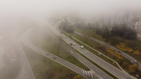 Road Traffic in the City in the Fog at the Summer Day Aerial View alt