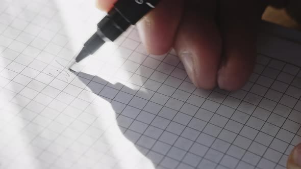 Caucasian Male's Hand with a Black Pen is Making Notes on a Paper