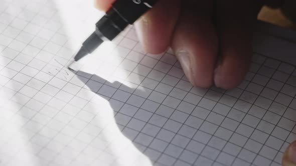 Caucasian Male's Hand with a Black Pen is Making Notes on a Paper alt