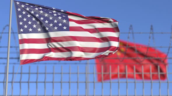 Waving Flags of the USA and China Separated By Barbed Wire alt
