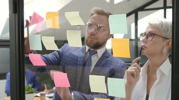 Male and Female Executive Colleagues Brainstorming Project in Office Meeting Room alt
