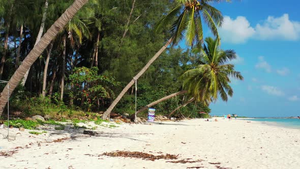 Aerial top down sky of idyllic island beach voyage by blue sea and white sandy background of a picni alt