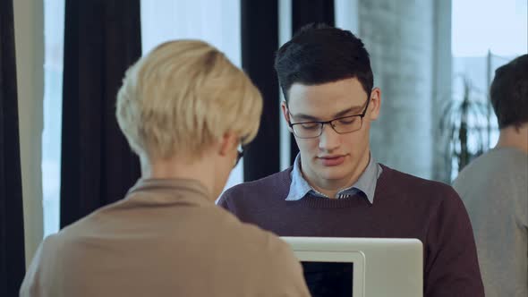 Two People Working in Cafe, Using Laptop and Drinking Cofe alt