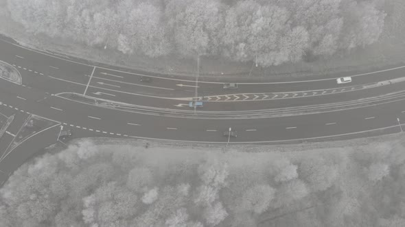 Above Winter Road With Traffic Surrounded By Forest Sideway Aerial