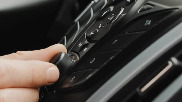 Male Hand Adjust the Volume or the Tuning of the Car Radio alt