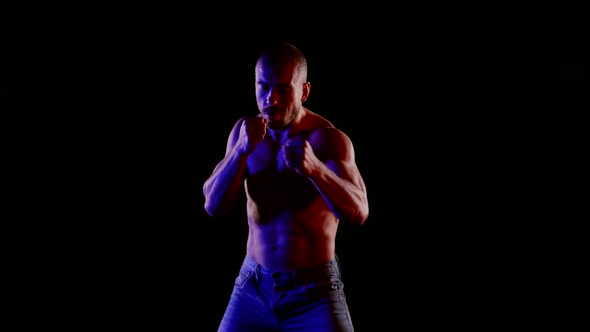 Fighter is Training Alone in Darkness Mysterious Blue Light on Naked Torso Silhouette alt