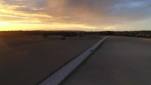 Car Driving on Country Road at Sunset Aerial View