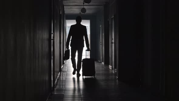 Businessman Going with Luggage along Corridor in Hotel