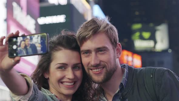 Couple taking selfie in Times Square, New York City, New York alt