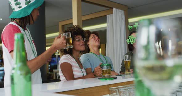 Diverse group of happy friends celebrating st patrick's day drinking beers at a bar alt