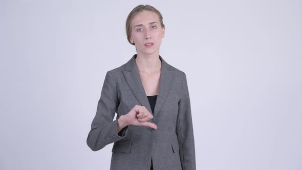 Young Stressed Blonde Businesswoman Giving Thumbs Down alt