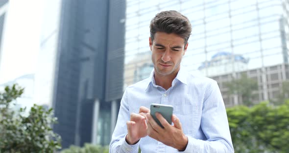 Business man use of cellphone in city alt