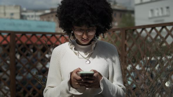 African American Woman Texting On Cell Phone alt