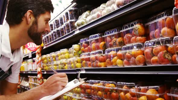 Male staff maintaining records of fruit alt