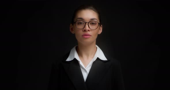 Business Woman in Glasses with a Serious Face Shows Ok Sign