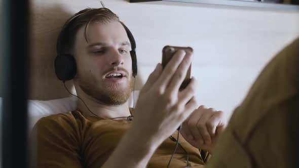 Portrait of Young Positive Man in Headphones Using Video Chat. Cheerful Handsome Caucasian Guy alt