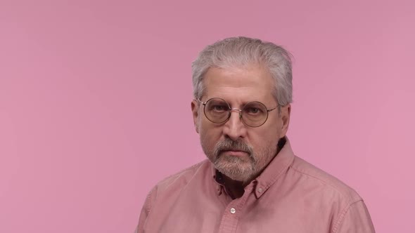 Portrait of an Elderly Man with Glasses Looking at Camera with Anticipation Then Very Upset alt