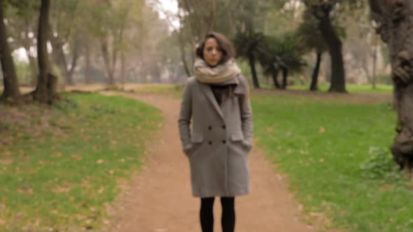 Lonely serious woman in the park, winter day-steady cam-change of focus alt