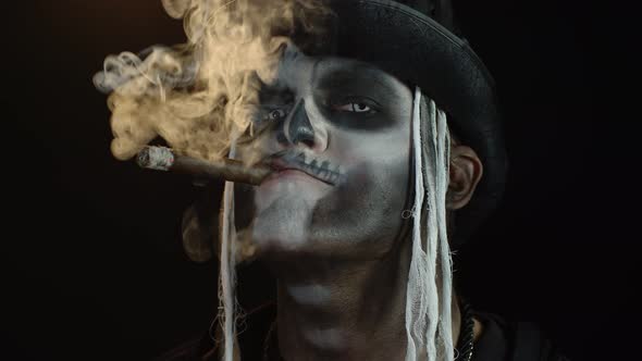 Frightening Man in Skeleton Halloween Cosplay Costume Smoking Cigar, Making Faces, Smiling alt