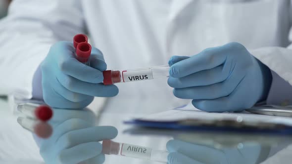 Lab Assistant Describing Test Tubes With Viruses and Adding Them to Database alt