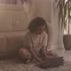 Biracial Girl Using Laptop while Sitting on Floor at Home - VideoHive Item for Sale