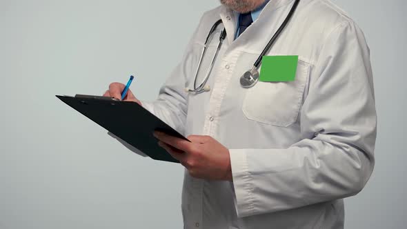 Male Doctor Takes Notes on a Medical History or Records His Research in a Black Folder alt