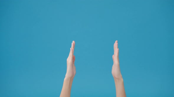 Young woman hand shows something amazing at blank space isolated over blue background in studio.