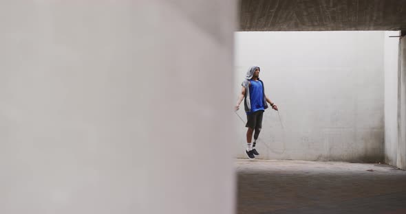 Side view man with prosthetic leg doing skipping rope alt