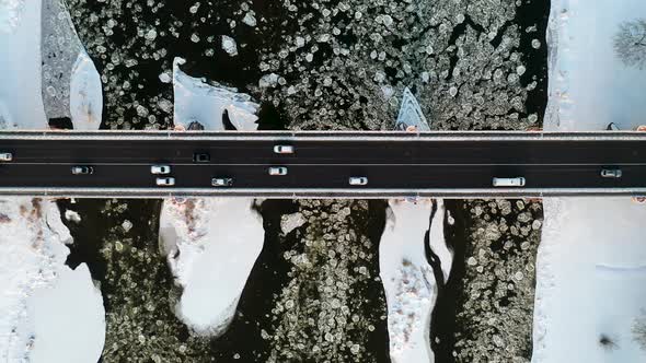 City Traffic On Bridge Over Frozen River In Winter Aerial View