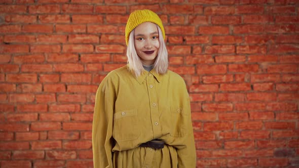Young Woman in Total Yellow Look. Portrait of Flirting Beautiful Girl on Bricks alt