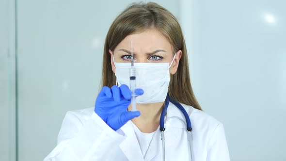 Close Up of Doctor in Mask Holding Injection alt