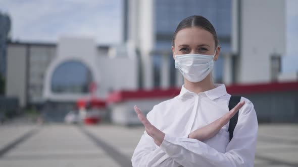 Serious Confident Young Woman Crossing Hands No Gesture Standing on City Square in Coronavirus Face alt