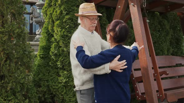 Caucasian elderly couple dancing together while listen to music outdoors, sweet couple enjoy love mo