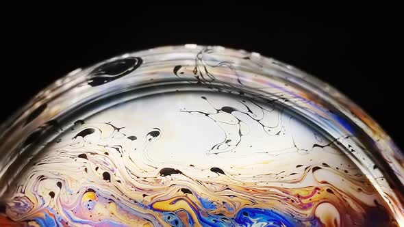 Slow Motion of Bright Neon Colored Patterns on the Surface of the Soap Bubble alt