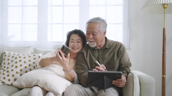 Asian senior couple in living room at home.