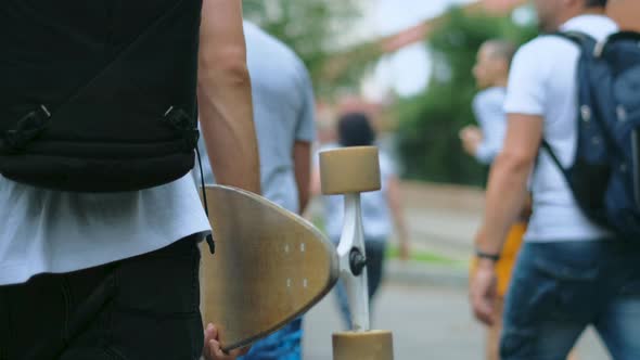 Rebel in Coronavirus Face Mask Holds Skate While Walking with People on Rally alt