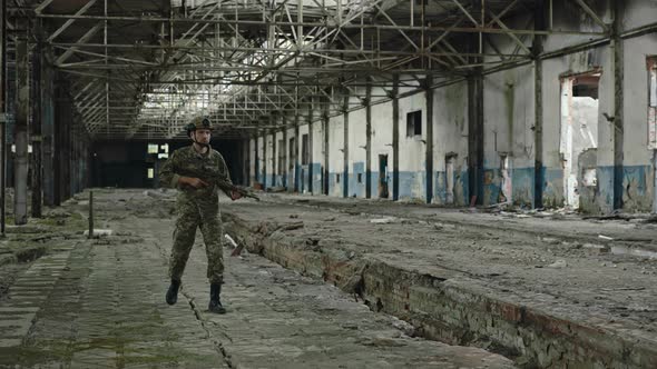 Soldier in Uniform Walking Through Abandoned Building alt