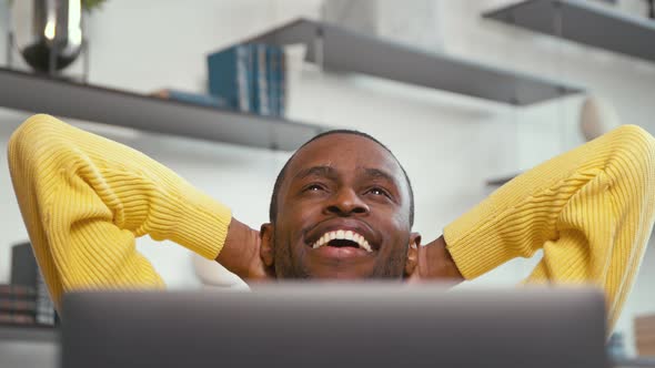 Happy man relaxing at work with laptop at home office. Young businessman with laptop indoors alt